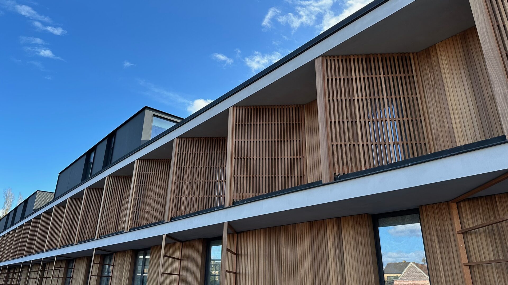 Modern gebouw met houten gevelbekleding door Schrijnwerken VQ